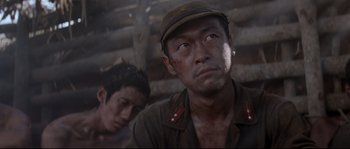 Movie still from “The Thin Red Line” (1998), directed by Terrence Malick – A man in a red hat and a man in a black shirt; Close Up shot, Low angle