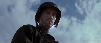 Movie still from “The Thin Red Line” (1998), directed by Terrence Malick – A man wearing a helmet and a uniform; Close Up shot, Low angle
