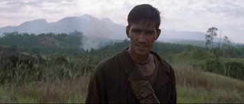 Movie still from “The Thin Red Line” (1998), directed by Terrence Malick – A man in a field wearing a brown jacket; Close Up shot, Over the shoulder angle