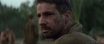 Movie still from “The Thin Red Line” (1998), directed by Terrence Malick – A person with a beard; Close Up shot, Over the shoulder angle