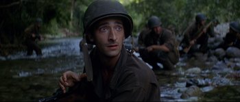 Movie still from “The Thin Red Line” (1998), directed by Terrence Malick – A man in a military uniform with a rifle; Close Up shot, High angle