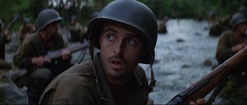 Movie still from “The Thin Red Line” (1998), directed by Terrence Malick – A man wearing a helmet while standing in the water; Close Up shot, Low angle
