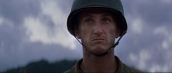 Movie still from “The Thin Red Line” (1998), directed by Terrence Malick – A man wearing a military helmet with a sky background; Close Up shot, Low angle