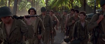 Movie still from “The Thin Red Line” (1998), directed by Terrence Malick – A group of soldiers walking down a dirt road; Medium shot, Low angle