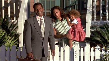 Movie still from “The Truman Show” (1998), directed by Peter Weir – A man and a woman and a little girl standing next to each other; Medium shot, Low angle