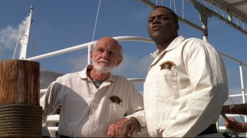 Movie still from “The Truman Show” (1998), directed by Peter Weir – Two men standing next to each other on a boat; Medium shot, Low angle
