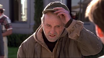 Movie still from “The Truman Show” (1998), directed by Peter Weir – An older man wearing a hat and a jacket; Close Up shot, Low angle