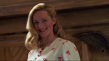 Movie still from “The Truman Show” (1998), directed by Peter Weir – A woman with blonde hair wearing a white and red dress; Close Up shot, Low angle