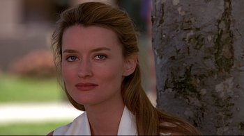 Movie still from “The Truman Show” (1998), directed by Peter Weir – A person wearing a white shirt near a tree; Close Up shot, Over the shoulder angle