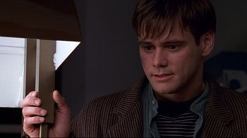 Movie still from “The Truman Show” (1998), directed by Peter Weir – A man holding an umbrella in a dark room; Close Up shot, Low angle