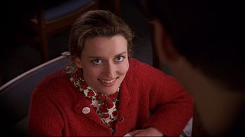 Movie still from “The Truman Show” (1998), directed by Peter Weir – A woman in a red sweater smiling for the camera; Close Up shot, High angle