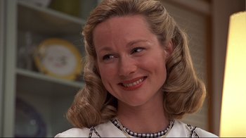 Movie still from “The Truman Show” (1998), directed by Peter Weir – A person wearing a dress smiling; Close Up shot, Low angle