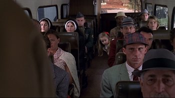 Movie still from “The Truman Show” (1998), directed by Peter Weir – A group of people sitting on a bus; Medium shot, High angle
