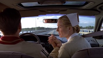 Movie still from “The Truman Show” (1998), directed by Peter Weir – A woman driving a car on a highway; Close Up shot, Over the shoulder angle
