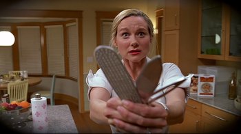 Movie still from “The Truman Show” (1998), directed by Peter Weir – A woman holding a pair of scissors in her hands; Close Up shot, Low angle
