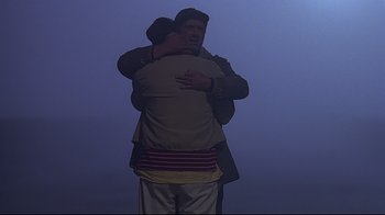 Movie still from “The Truman Show” (1998), directed by Peter Weir – Two men hugging each other in the dark; Medium shot, Low angle