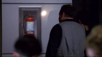 Movie still from “The Truman Show” (1998), directed by Peter Weir – A man standing in front of a fire hydrant; Close Up shot, Over the shoulder angle