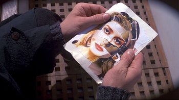 Movie still from “The Truman Show” (1998), directed by Peter Weir – A person holding a piece of paper in their hands; Extreme Close Up shot, Overhead angle