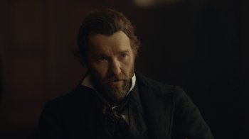 Movie still from “The Underground Railroad” (2021), directed by Barry Jenkins – A person wearing a suit and tie; Close Up shot, Over the shoulder angle