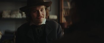 Movie still from “The Underground Railroad” (2021), directed by Barry Jenkins – A man wearing a hat and a coat; Close Up shot, Over the shoulder angle