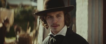 Movie still from “The Underground Railroad” (2021), directed by Barry Jenkins – A man in a hat and a tie; Close Up shot, Low angle