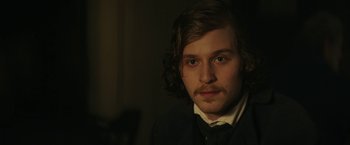 Movie still from “The Underground Railroad” (2021), directed by Barry Jenkins – A man with a beard and mustache wearing a suit and tie; Close Up shot, Over the shoulder angle