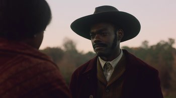 Movie still from “The Underground Railroad” (2021), directed by Barry Jenkins – A man wearing a hat and a jacket; Close Up shot, Over the shoulder angle