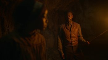 Movie still from “The Underground Railroad” (2021), directed by Barry Jenkins – A man and a woman standing in a dark cave; Medium shot, Over the shoulder angle
