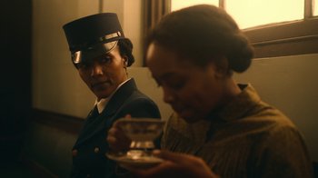 Movie still from “The Underground Railroad” (2021), directed by Barry Jenkins – A man and a woman are standing next to each other; Medium shot, Over the shoulder angle