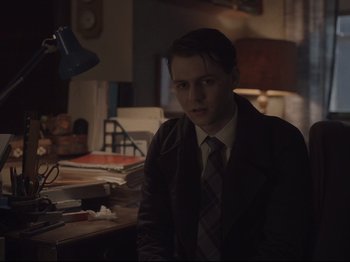 Movie still from “The Whale” (2022), directed by Darren Aronofsky – A man in a suit sitting at a desk; Medium shot, High angle