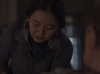 Movie still from “The Whale” (2022), directed by Darren Aronofsky – A woman with a stethoscope around her neck looking down; Medium shot, Over the shoulder angle