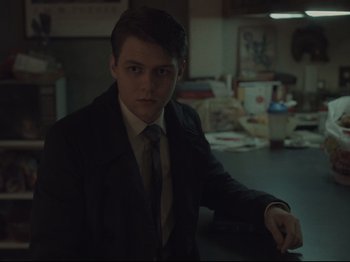 Movie still from “The Whale” (2022), directed by Darren Aronofsky – A man in a suit and tie sitting at a table; Medium shot, Over the shoulder angle