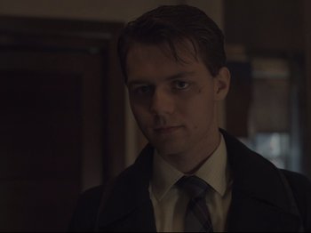 Movie still from “The Whale” (2022), directed by Darren Aronofsky – A man wearing a suit and tie standing in front of a door; Close Up shot, Low angle