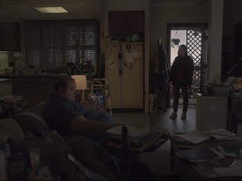 Movie still from “The Whale” (2022), directed by Darren Aronofsky – A man sitting on a couch in a living room; Wide shot, Low angle