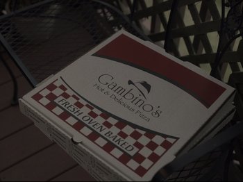 Movie still from “The Whale” (2022), directed by Darren Aronofsky – A pizza box sitting on top of an outdoor table; Extreme Close Up shot, High angle