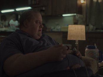 Movie still from “The Whale” (2022), directed by Darren Aronofsky – A man sitting in a chair playing a video game; Medium shot, Over the shoulder angle
