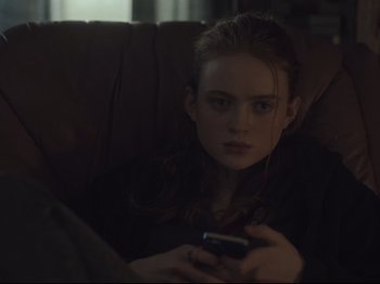 Movie still from “The Whale” (2022), directed by Darren Aronofsky – A woman sitting on a couch looking at a cell phone; Close Up shot, Over the shoulder angle
