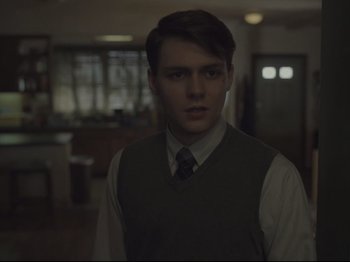 Movie still from “The Whale” (2022), directed by Darren Aronofsky – A man in a vest and tie in a dark room; Close Up shot, Over the shoulder angle
