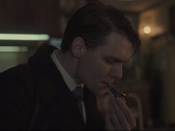 Movie still from “The Whale” (2022), directed by Darren Aronofsky – A man smoking a cigarette in a dark room; Close Up shot, Low angle