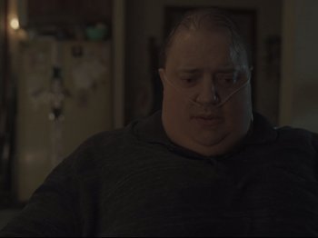 Movie still from “The Whale” (2022), directed by Darren Aronofsky – A fat man with a nose ring in a dark room; Close Up shot, Low angle
