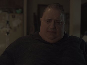 Movie still from “The Whale” (2022), directed by Darren Aronofsky – A person wearing glasses and a black shirt; Close Up shot, Over the shoulder angle