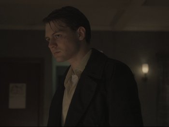 Movie still from “The Whale” (2022), directed by Darren Aronofsky – A man wearing a suit and tie standing in a room; Close Up shot, Low angle
