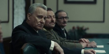 Movie still from “Chernobyl” (2019), directed by Johan Renck – A group of men sitting next to each other in a room; Medium shot, Low angle