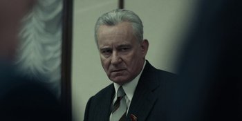 Movie still from “Chernobyl” (2019), directed by Johan Renck – An older man wearing a suit and tie; Close Up shot, Low angle