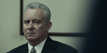 Movie still from “Chernobyl” (2019), directed by Johan Renck – An older man wearing a suit and tie; Close Up shot, Low angle