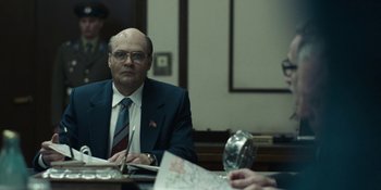 Movie still from “Chernobyl” (2019), directed by Johan Renck – A man sitting at a table in front of a map; Medium shot, Over the shoulder angle