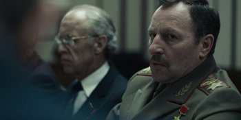 Movie still from “Chernobyl” (2019), directed by Johan Renck – Two men in military uniforms sitting next to each other; Close Up shot, Over the shoulder angle