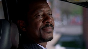 Movie still from “The Wire” (2002), created by David Simon – A person with a suit and tie on; Close Up shot, Low angle