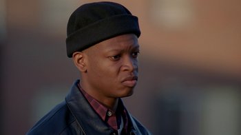 Movie still from “The Wire” (2002), created by David Simon – A person wearing a hat; Close Up shot, Low angle