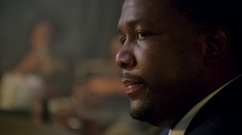 Movie still from “The Wire” (2002), created by David Simon – A person wearing a suit and tie; Close Up shot, Low angle